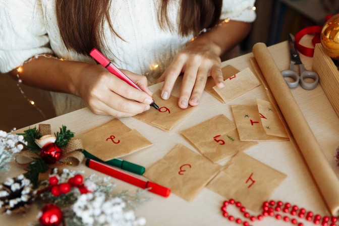 Frau bemalt Tüten für selbstgemachten Adventskalender