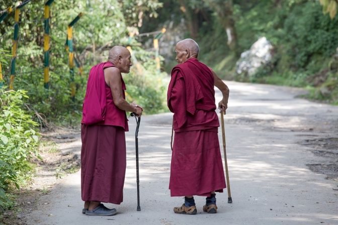 Alte Männer in lila Gewand auf einer Straße am Himalaya