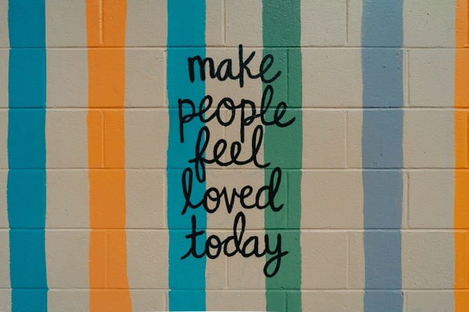 Auf einer Wand steht Make people feel loved