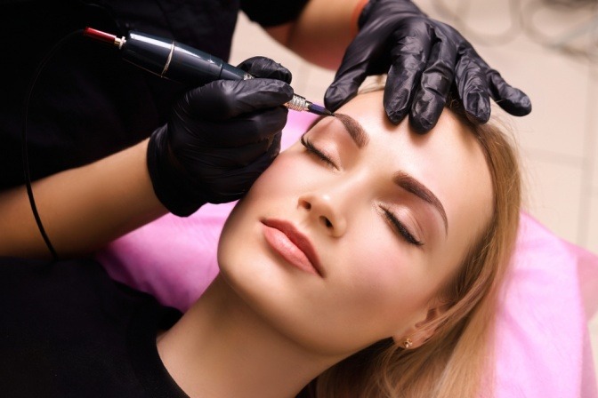 Frau beim Permanent Make-up um ihre dünnen Augenbrauen zu schminken