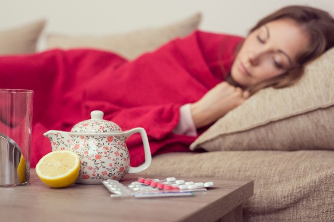 Erkältete Frau ruht sich auf dem Sofa aus