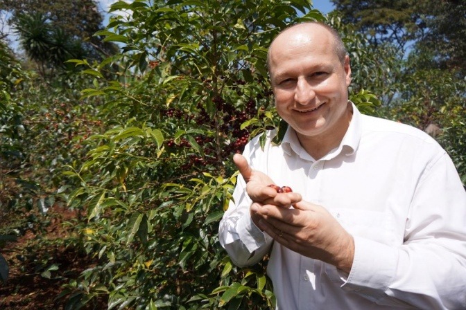 Hartwig Kirner von Fairtrade hält eine fair angebaute Frucht in der Hand