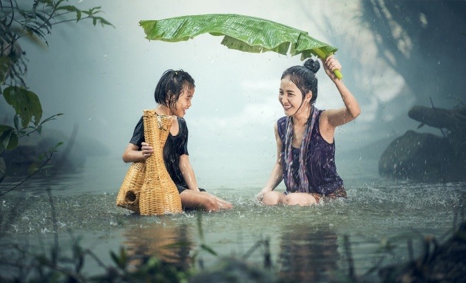 Eine Frau und ein Kind mit gutem Immunsystem sitzen im Wasser