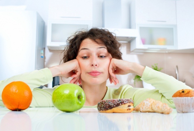 Eine Frau muss sich zwischen Lebensmitteln, die gesund und doch nicht gesund sind, entscheiden