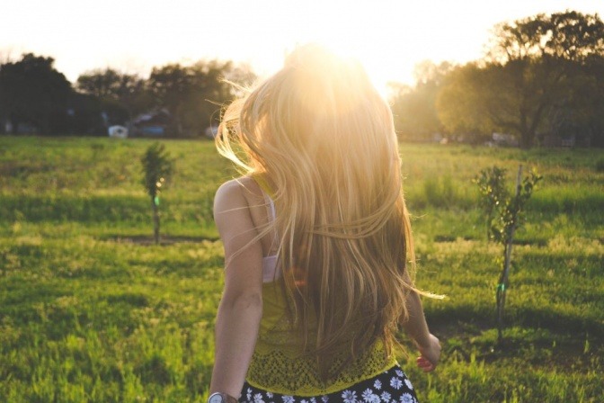 Eine Frau mit langen blonden Haaren befindet sich in der Natur