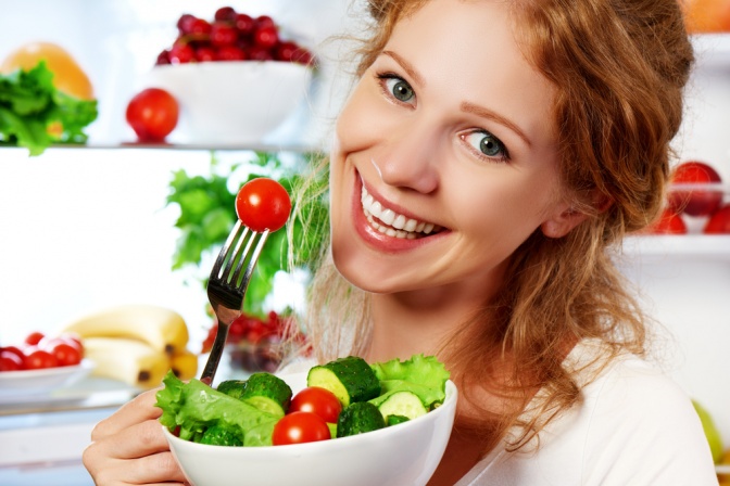 Eine Frau mit einem Teller Obst und Gemüse