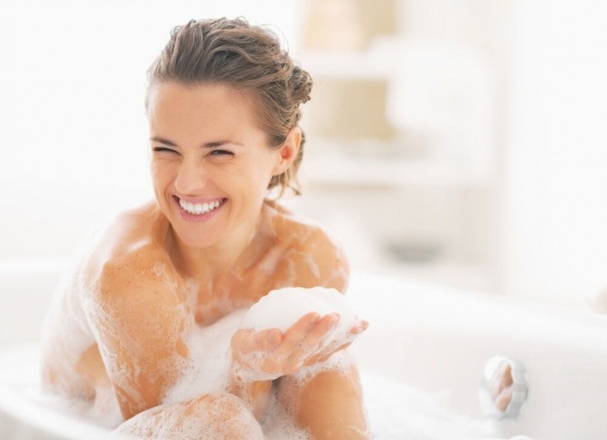 Eine glückliche Frau sitzt in der Badewanne