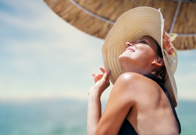 Eine Frau sitzt im Sommer im Schatten