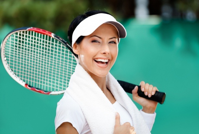 Eine Frau hält einen Tennisschläger zum Beschleunigen des Fettabbaus