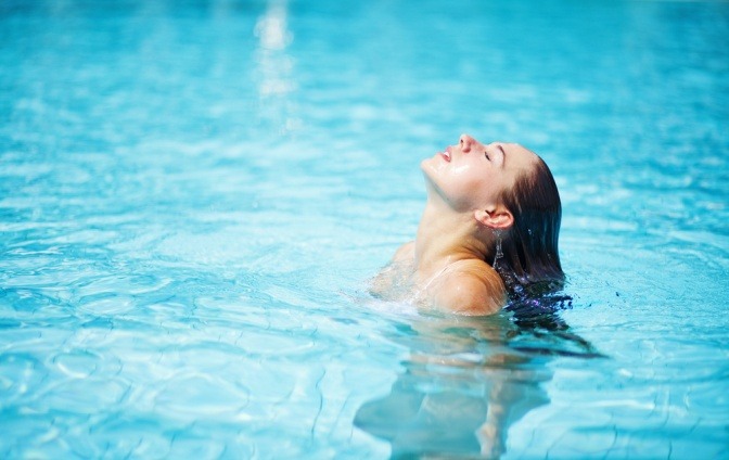 Eine Frau im Wasser atmet durch die Brust