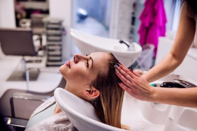 Eine Frau sitzt beim Friseur um Haare zu färben