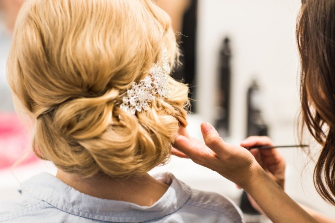 Eine Frau richtet Haare für ein Hochzeitsstyling