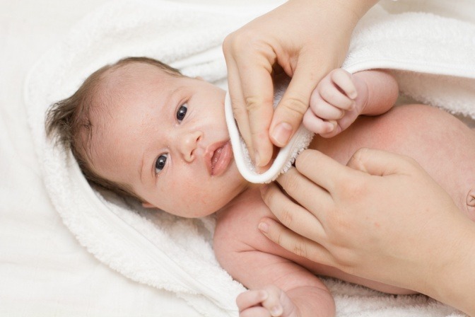 Bei einem Baby wird Hautpflege gemacht