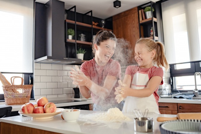 Mutter und Tochter backen zusammen einen Apfelkuchen