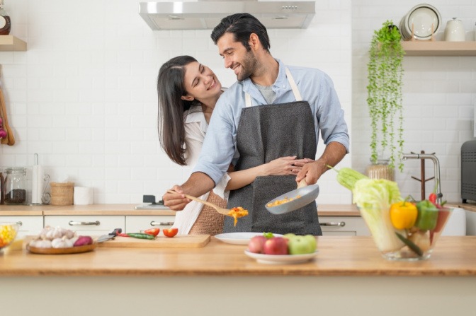 Fröhliches Paar beim gemeinsamen Kochen.