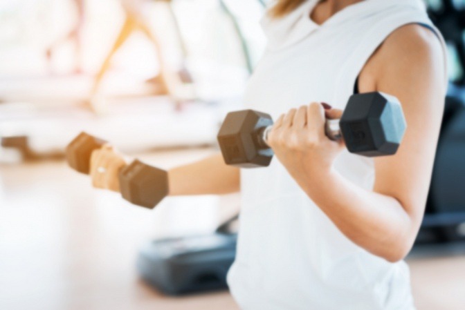 Frau mit Hanteln im Fitnessstudio