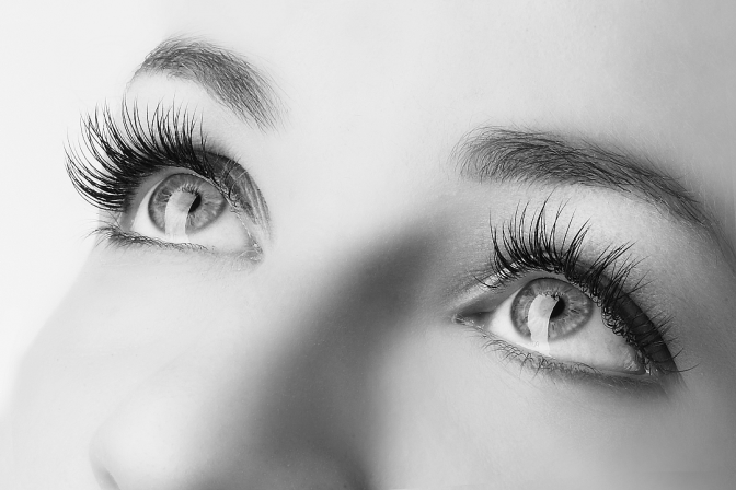 Ein Ausschnitt von einem Frauengesicht in Schwarz-Weiss zeigt die Augen mit langen schönen Wimpern