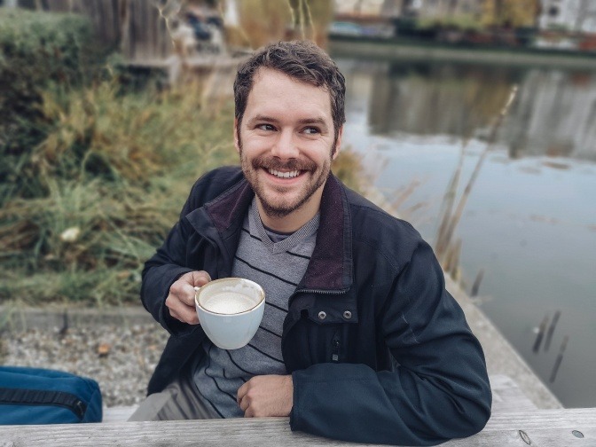 Mann mit Tasse lächelt als Zeichen der Zuneigung