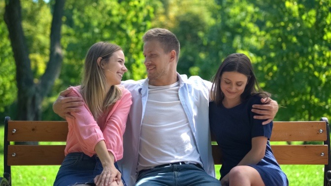 Kann man mehrere Menschen lieben, wie der Mann in diesem Bild, der zwei Frauen umarmt?