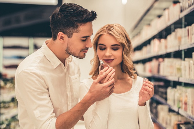 Frau und Mann riechen an einem Parfum