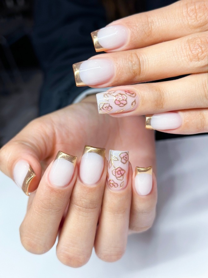 Finger mit Golden French Nails metallisch glänzend als Nagellack-Trend 2025