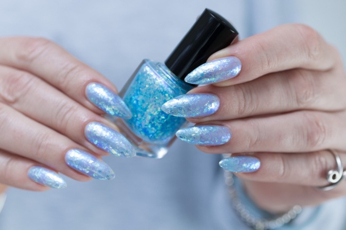 Nägel in Meeresblau mit holografischen Elementen als Nagellack-Trend 2025