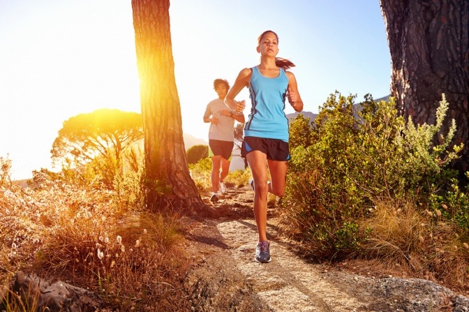 Frau beim Trail-Running im Wald um Reaktion zu verbessern