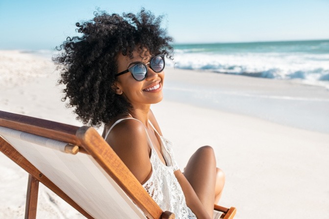 Glückliche Frau am Strand als Reiseziel im August