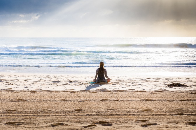 Frau meditiert am Meer