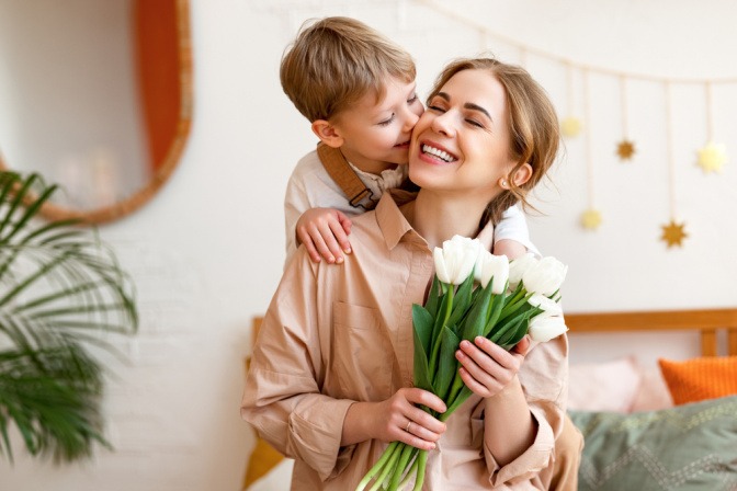 Bub schenkt seiner Mutter weiße Tulpen