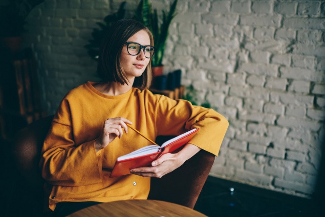 Frau im Sternzeichen Fische mit Brille und Buch