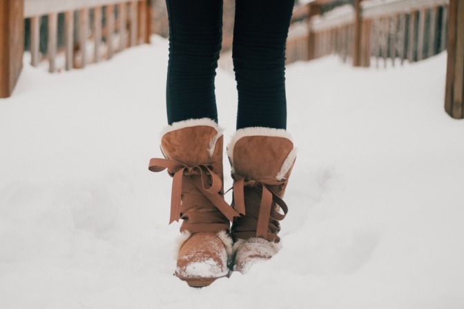 Eine Frau hat im Winter Stiefel mit Lammfell an