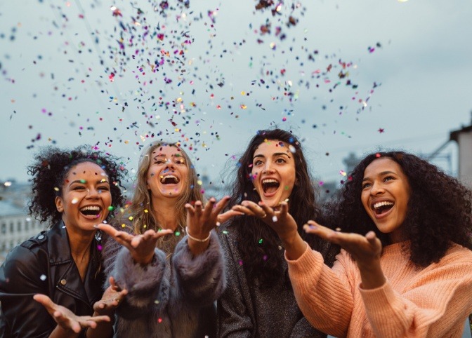 Eine Gruppe von Freunden wirft Confetti in die Luft