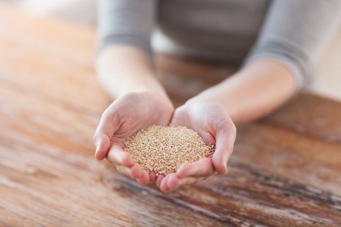 Eine Frau hält Quinoa-Samen in ihren Händen. 