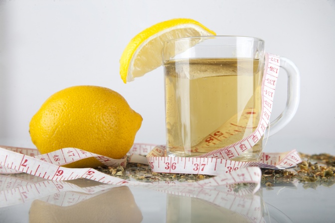 Ein Maßband ist über eine Tasse Detox Tee gewickelt