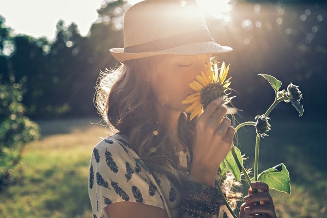 Eine Frau riecht an einer Blume.