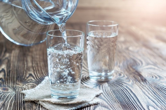 Wasser wird in ein Glas gefüllt und kann helfen, verklebte Faszien zu lösen