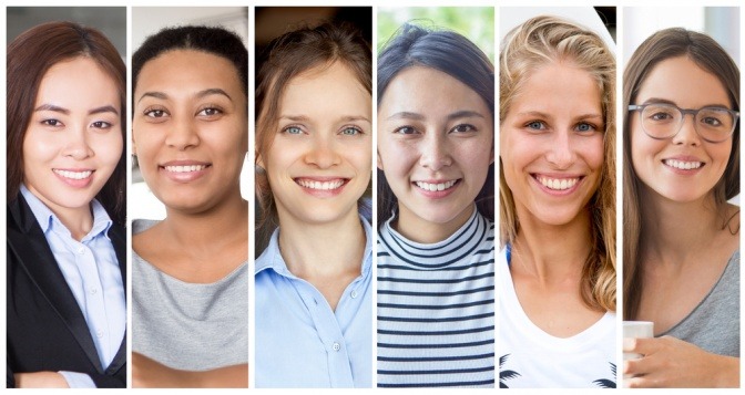 Frauen mit diversen Ethnien nebeneinander gestellt, sie lächeln in die Kamera.