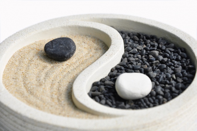 Ein Yin-Yang Symbol wird mit Sand und Steine dargestellt