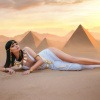Schöne Frau im Stil des alten Ägyptens liegt vor Pyramiden