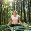 Frau beim Waldbaden in der Übung Meditation