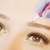 Frau bei einer Microblading Behandlung der Augenbrauen