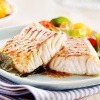 Ein Fisch für ein Gericht für mediterrane Küche liegt auf einem Teller