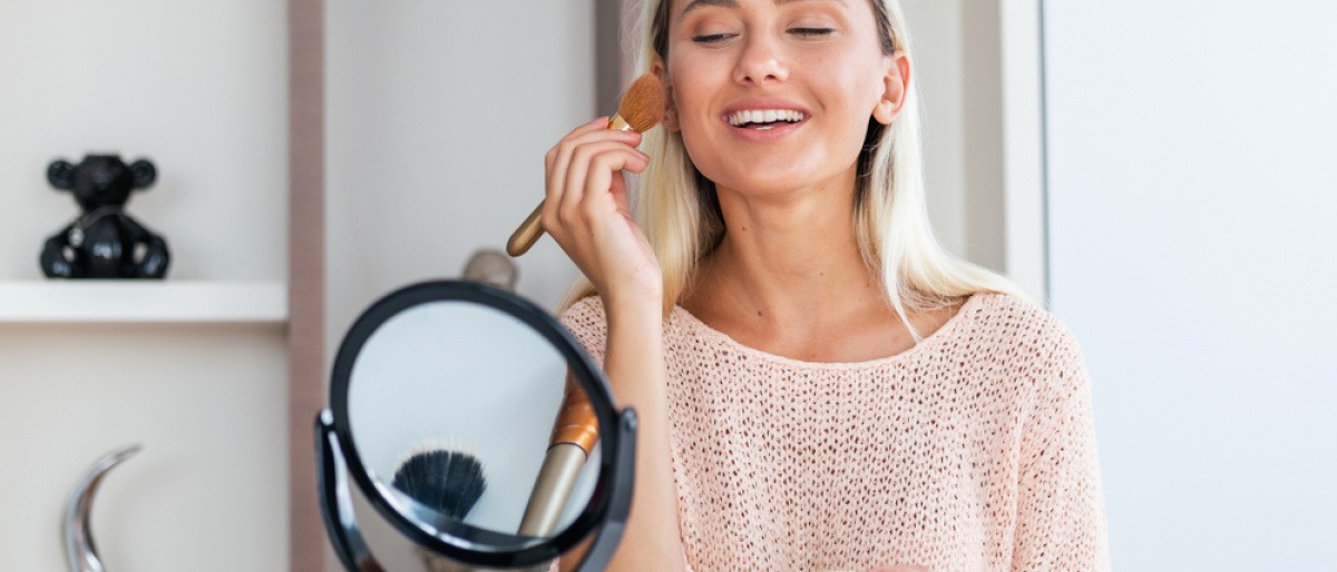 Frau schminkt sich und beherzigt Highlighter-Tipps