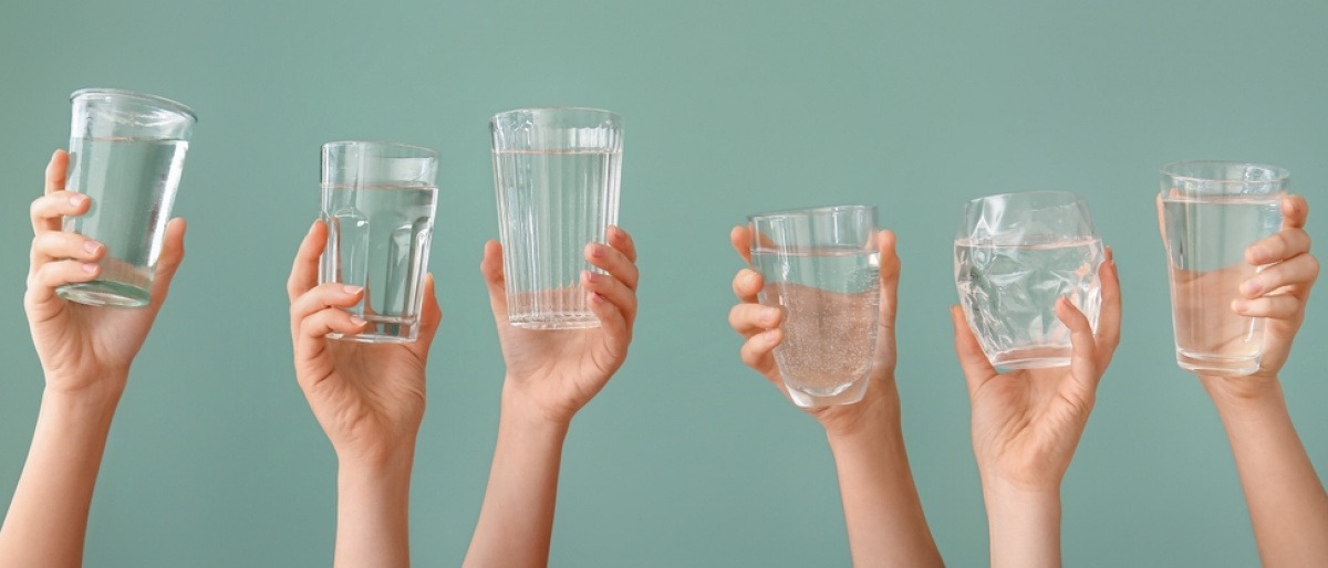 Hände halten Gläser mit Trinkwasser in die Luft