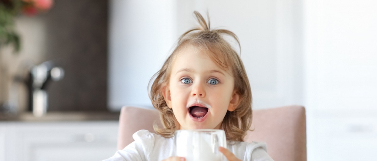 Kind trinkt Milch als calciumreiches Lebensmittel