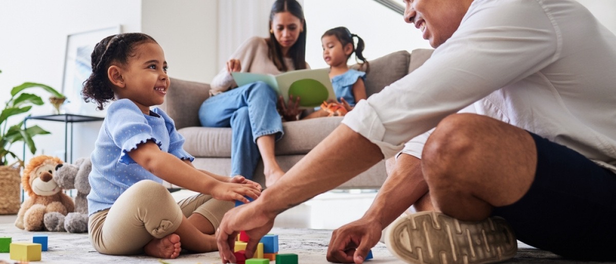 Mann und kleines Mädchen spielen als Familienaktivität mit Bausteinen