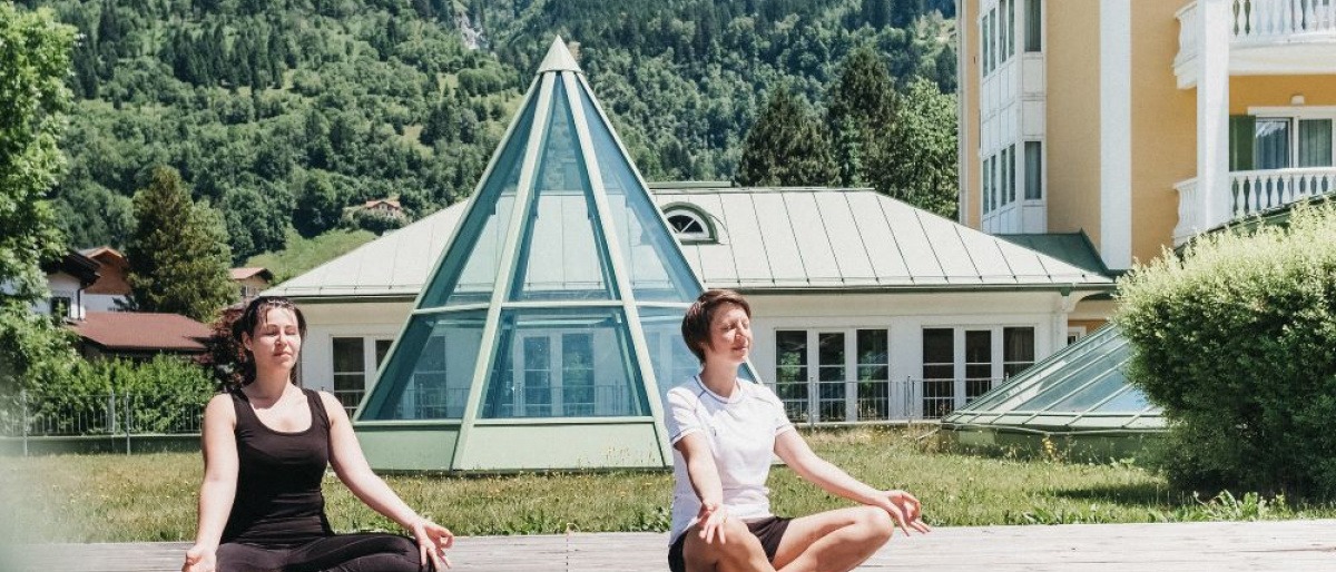 Zwei Frauen meditieren im Grünbereich des Hotel Alpenhaus Gasteinertal