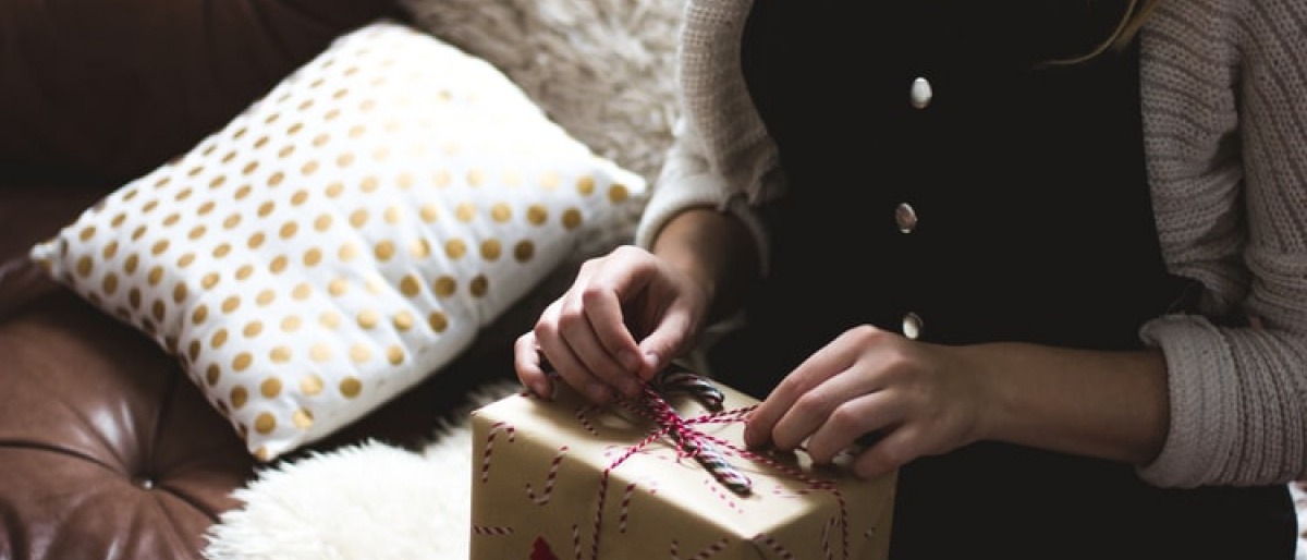 Eine Frau packt ein Geschenk aus