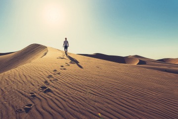 Fußspuren im Sand als Symbol für Gehmeditation